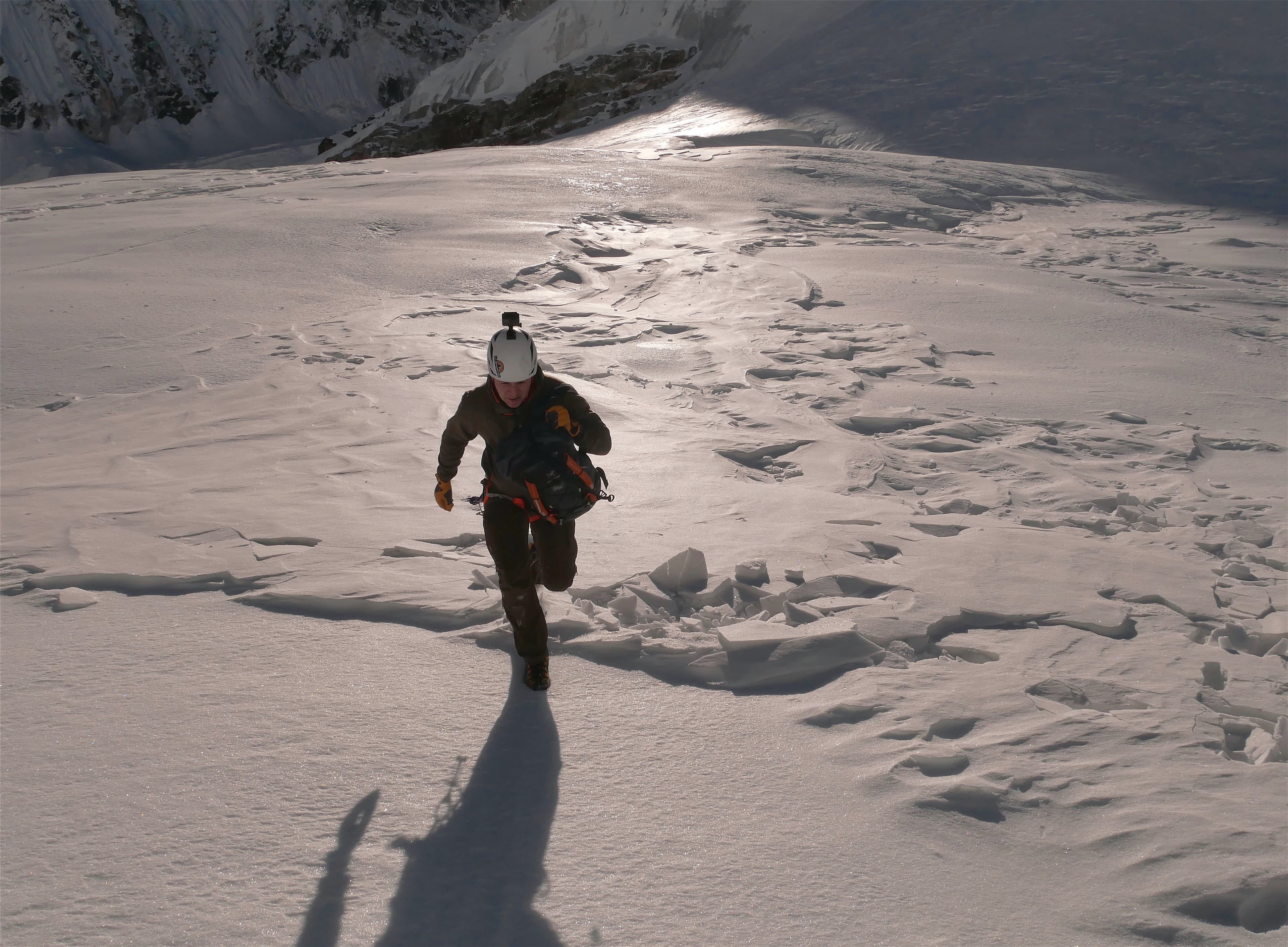 Gethin Davies, CEO of East Himal, running to a helicopter in snow conditions